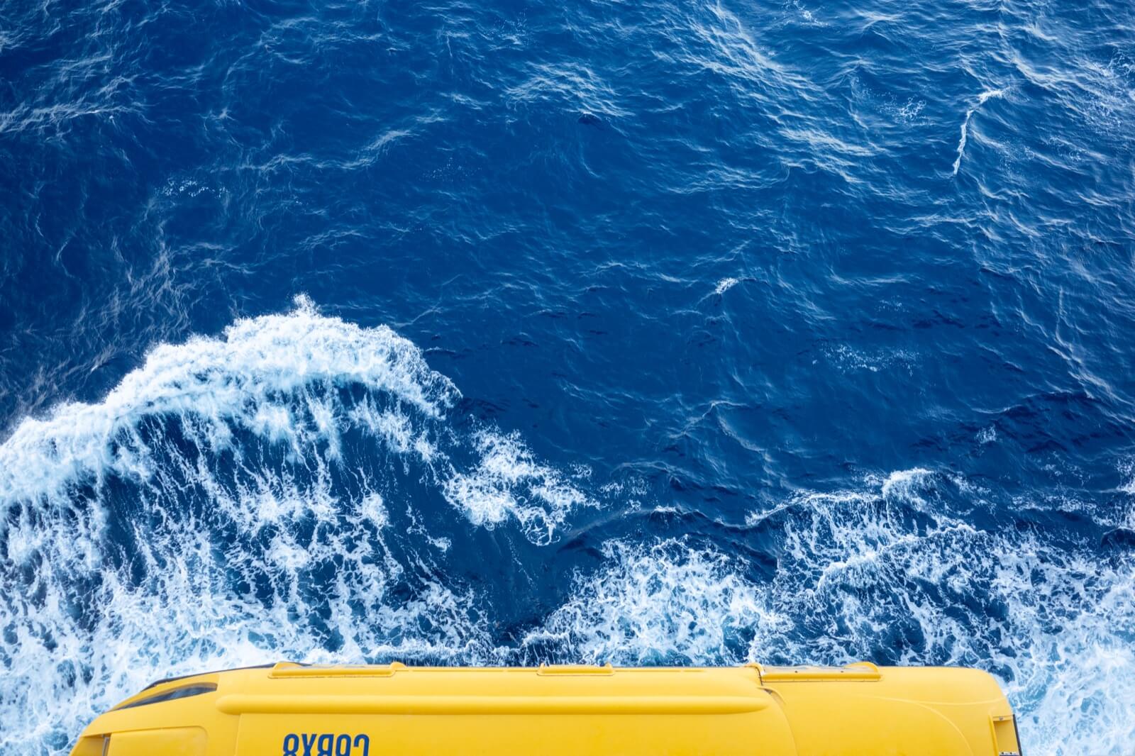 A yellow lifeboat on the Harmony of the Seas, seen from above against the blue ocean